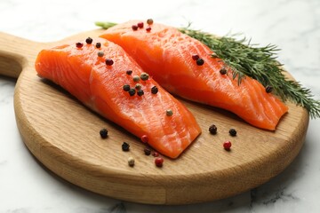 Seafood. Pieces of salmon fillet and spices on white marble table, closeup