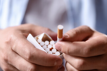 Man taking cigarette out of pack, closeup. Smoking