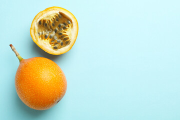 Ripe yellow passion fruits on light blue background, flat lay. Space for text