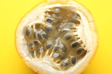 Piece of ripe passion fruit on yellow background, closeup
