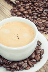 Coffee in cup and roasted dark coffee beans