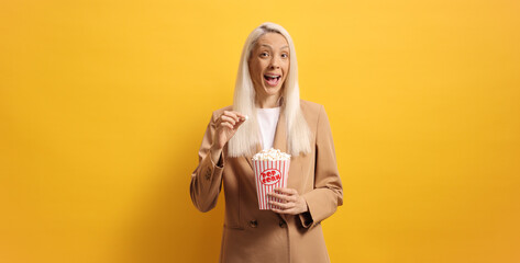 Excited woman holding a box of popcorn
