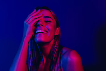 Bright portrait of a young woman smiling in neon blue and pink lights