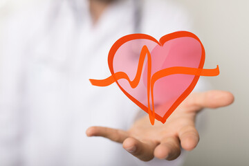 Image of a doctor's hand holding a heart with a heartbeat graphic, symbolizing healthcare and...