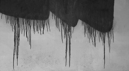 close up of black paint flowing leaking on white concrete plaster stucco wall background.