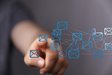 Hand pointing at digital email icons, networking concept.  Communication, connection, technology.