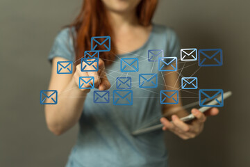 Stock photo of a woman interacting with a network of email icons, illustrating email management and...