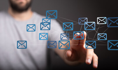 Hand interacting with a digital network of email icons, representing global communication and...