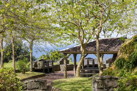 Picknick Platz am Aussichtspunkt inmitten gr&uuml;ner Natur auf den Azoren, Atlantischer Ozean im Hintergrund