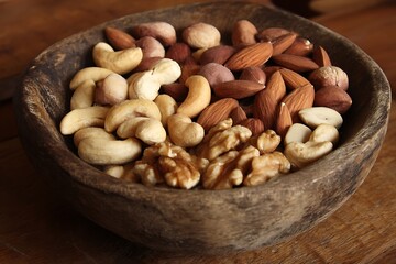 Close up of almonds walnuts cashews in bowl on table  
