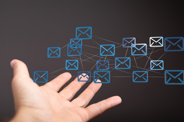 Hand holding network of email icons.  Digital communication, global connectivity.
