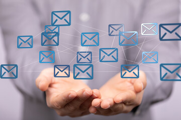 Image of hands holding a network of email icons, representing global communication and connectivity.