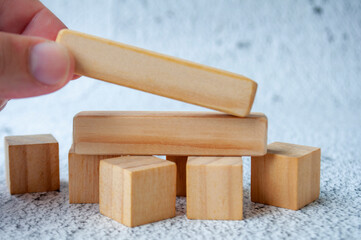 Close up of hand putting a wooden blocks with customizable space for text