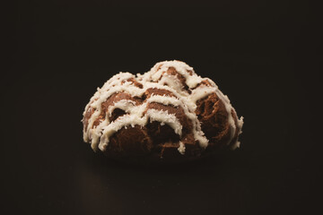 Profiteroles with coconut cream on a black background.