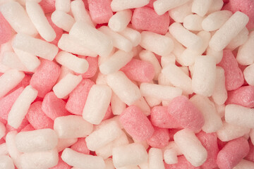 Pink and white box filler as a background. Top view.