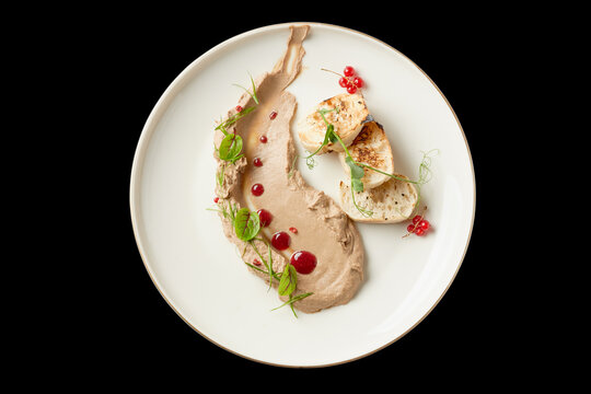 Creative culinary presentation of grilled chicken on a minimalist plate with sauce and garnishes