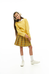 Charming asian schoolgirl showcasing a trendy school uniform in a bright studio setting