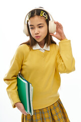 Stylish schoolgirl showcases trendy outfit in vibrant studio setting