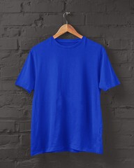 Royal blue T-shirt mockup on hanger placed on a black brick wall for print on demand