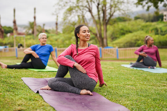 Group of multi generational women doing yoga exercise at park - Diverse people, healthy lifestyle and community concept