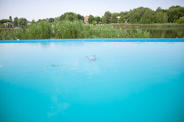 Automatic robot cleans the swimming pool underwater. Pool cleaning. Selective focus.