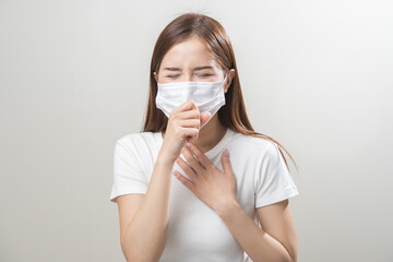 Unhealthy sickness, unwell asian young woman wearing mask coughing, have sore throat, suffering symptom cough feeling bad and healthcare of air pollution and dust, PM2.5 isolated white background.