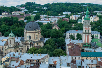 From above the picturesque cityscape of Lviv Ukraine unfolds revealing its old buildings diverse architecture and notable towers surrounded by trees 