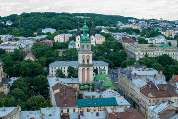 From above the picturesque cityscape of Lviv Ukraine unfolds revealing its old buildings diverse architecture and notable towers surrounded by trees 