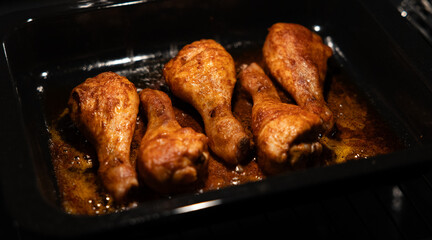 Roasted chicken legs in the baking oven. Golden fried chicken pieces in the kitchen, ready to eat.
