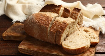 Pieces of fresh bread on wooden table, closeup
