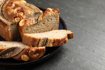 Cut banana bread with nuts on black table, closeup. Space for text