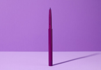 One twist up eye pencil on purple background, closeup