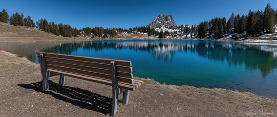 Obraz premium In the heart of Switzerland's Berner Oberland, the Oeschinnensee lake shines with its vibrant turquoise color, surrounded by breathtaking waterfalls, a traditional wooden chalet, and the stunning