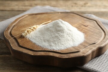 Wheat flour and spikelet on wooden table, closeup