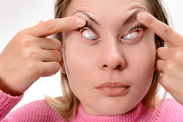 Woman widening her eyes with fingers