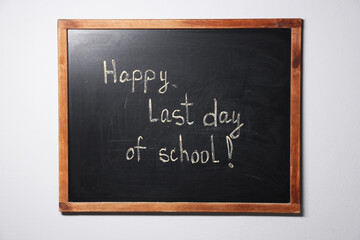 Obraz premium Phrase Happy Last Day of School with exclamation mark on blackboard