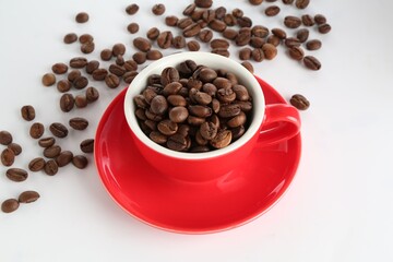 Ceramic cup with roasted coffee beans on white background