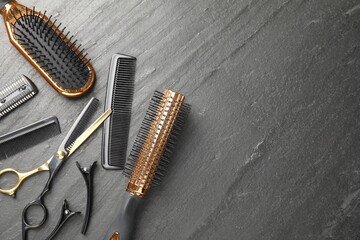 Different hairdresser's tools on dark table, flat lay. Space for text