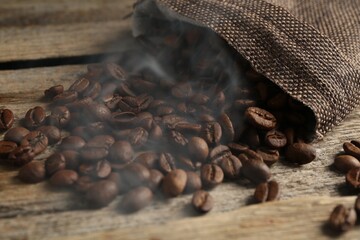 Aromatic coffee beans on wooden table, closeup