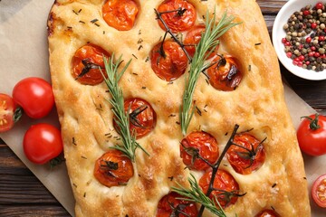 Delicious focaccia with tomatoes and spices on table, flat lay