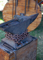 Close-up of a blacksmiths hand holding metal rod on anvil with hammer during traditional forging demonstration