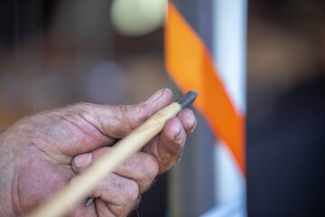 Close-up of adult hand holding an arrow during traditional archery teaching moment at historical...