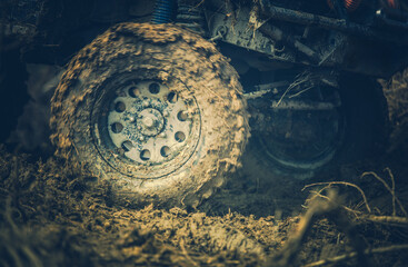 Off-road Vehicle Navigating Through Muddy Terrain During the Late Afternoon, Showcasing Powerful Tire Traction and Rugged Wheels