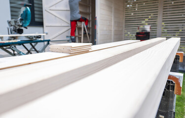 Carpenter Working on a Wood Project With Planks and Tools During a Bright Day in a Residential Yard