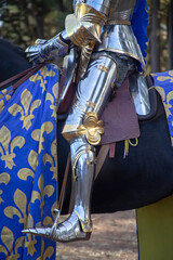 Close-up of knight’s leg armor and stirrup detail during historical reenactment