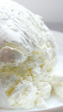 Making cottage cheese, homemade fermenting dairy product. Homemade cottage cheese in cheesecloth bags on kitchen table, woman hands drain cheese at home top view copy space. High quality 4k footage
