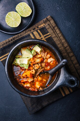 Spicy red curry soup with chicken, shrimps and avocado