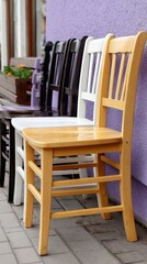 Five chairs in purple and yellow stand against a dark background, showcasing contrast and symbolizing diversity in a workspace