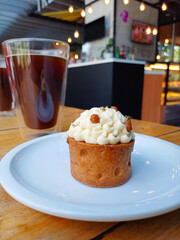 Pastel de avena y crema batida, acompañado de un vaso de café.