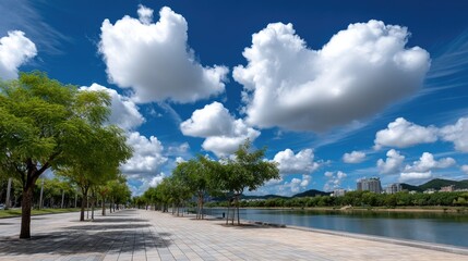 Fototapeta premium Clear blue sky and white clouds create a tranquil setting at West Lake in Hangzhou, with trees framing a stunning urban backdrop
